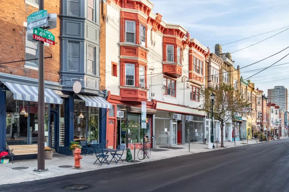 Row of three-story buildings with stores and restaurants with awnings on ground floor in Philadelphia, Pennsylvania.